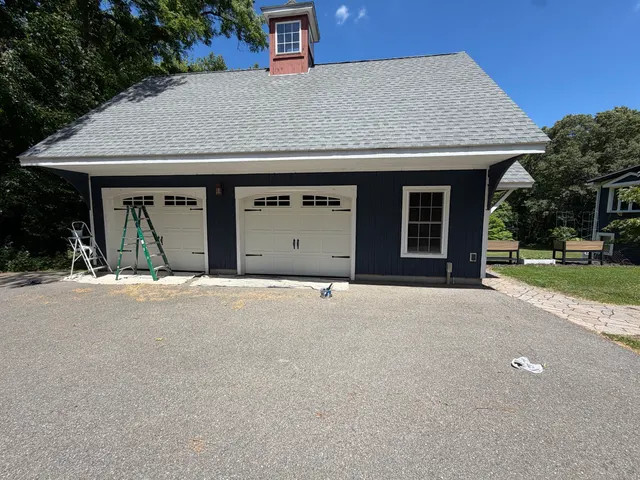 Detached garage with gray siding and white trim