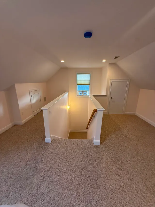 Finished attic room with light walls and carpeting