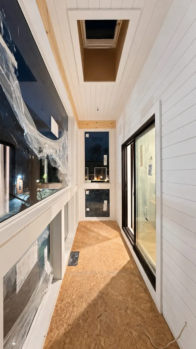 Enclosed porch with white window trim and a wood floor