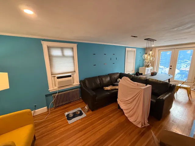 Living room with blue walls and furniture protected for work