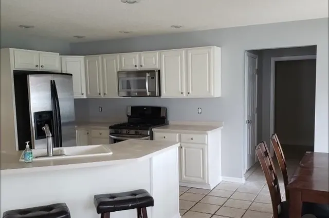 White kitchen cabinetry, island and tile flooring