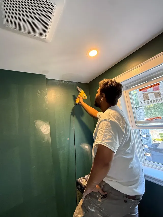 Crew member applying paint to an interior wall