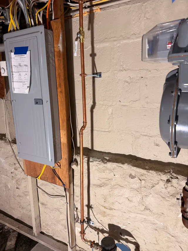 Open interior wall framing beside an electrical panel
