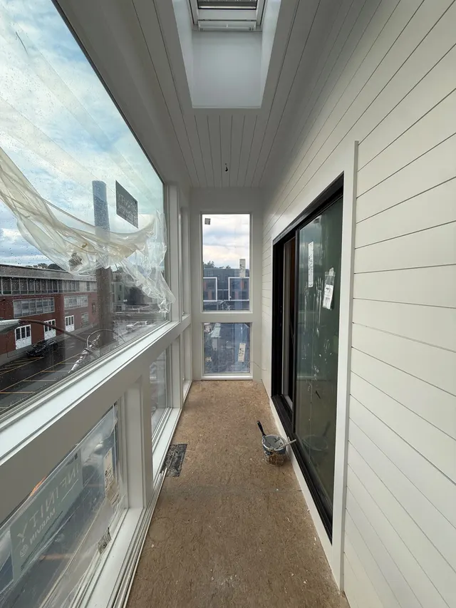 White-framed windows along a bright enclosed porch