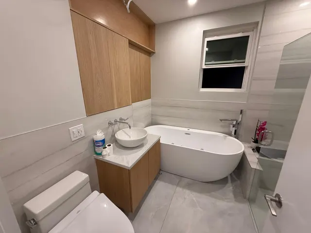 Bathroom with vanity, toilet, tile and a glass shower enclosure